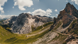 Mountains and valleys against a blue sky with clouds