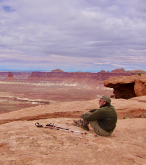 A hiker sitting on a plateau admiring the view