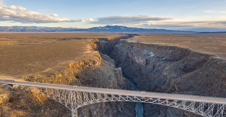 A silver-colored bridge spanning a deep chasm