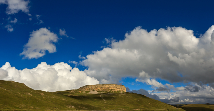 A plateau seen in the distance against a dark blue sky