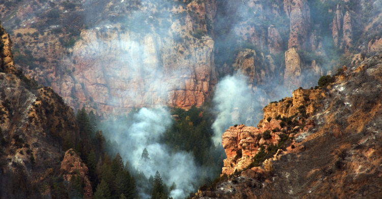 Smoke rising from a deep chasm in the mountains