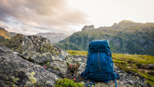 An abandoned blue hiking backpack in a mountain landscape