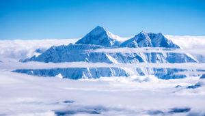 Snowy blue and white majestic mountains seen through clouds