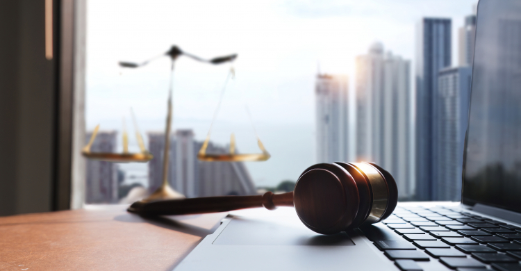 A judge's gavel lying on a computer