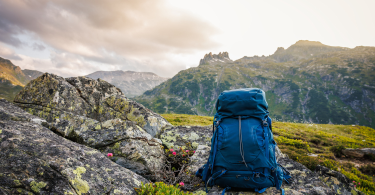 An abandoned blue hiking backpack in a mountain landscape